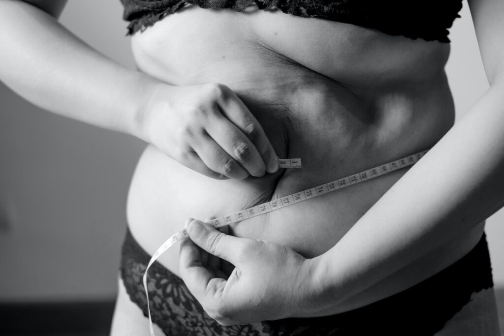 grayscale photo of woman holding her breast